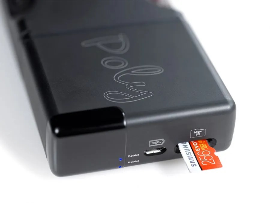 A 256 GB microSD card being pushed into the Poly's card slot, beside the micro-USB port and the two blue status LEDs